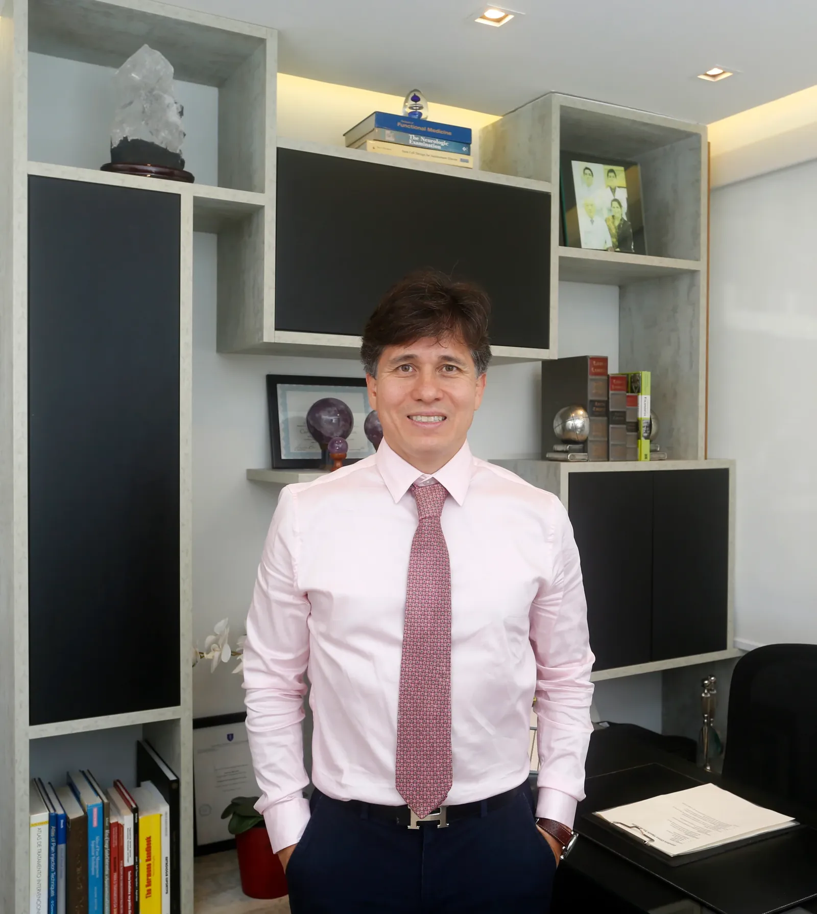 Dr. Rafael Higashi em pé no consultório